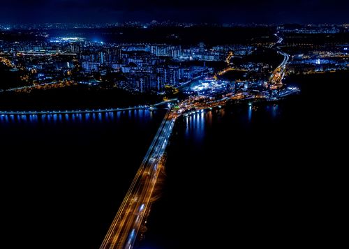 An aerial view of a causeway connecting Malaysia and Singapore at night.